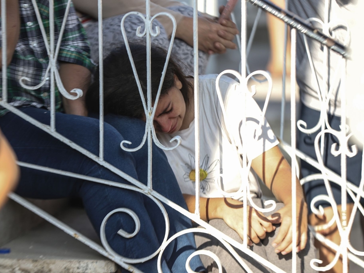 Женщина плачет после израильского авиаудара по городу Газа.