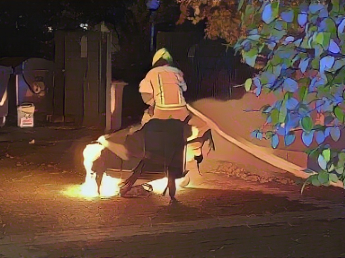 Ein Feuerwehrmann löscht eine brennende Mülltonne in der Halloween-Nacht 