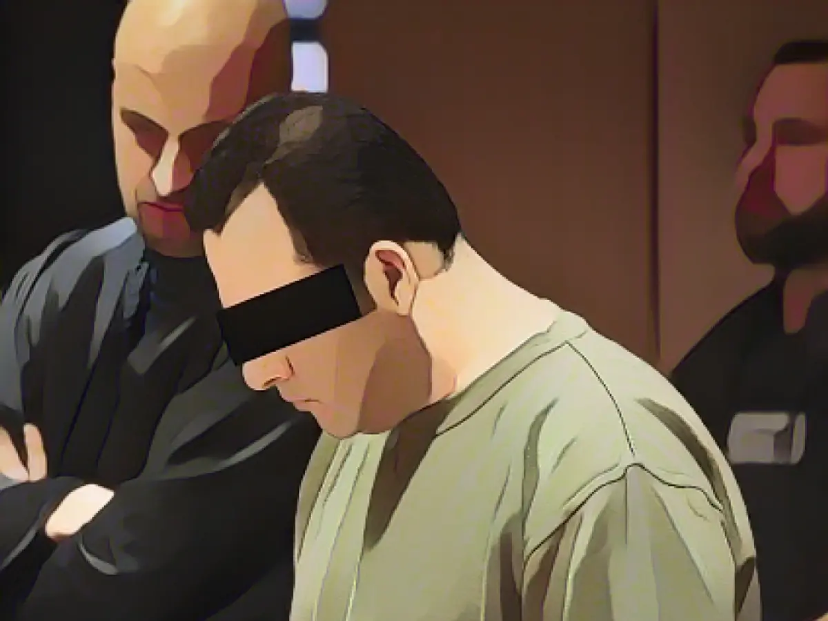 Ugur S. hid behind a folder, next to him his defense lawyer Ugur S. in court, flanked by his defense lawyer