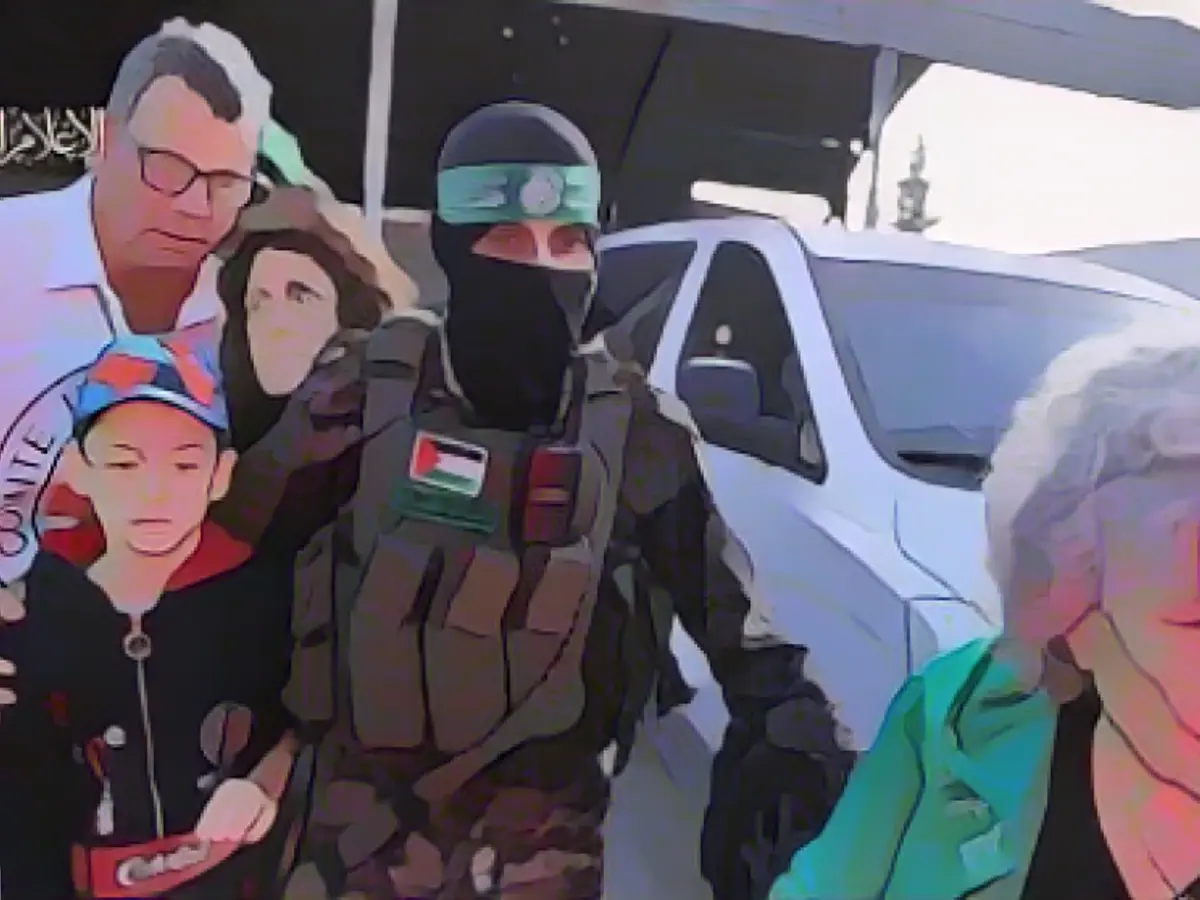 Masked Hamas terrorists handed Ohad (left) over to the Red Cross on Friday as part of the hostage deal Emotional Reunion: Avi Zichri and his son Ohad in an Israeli hospital