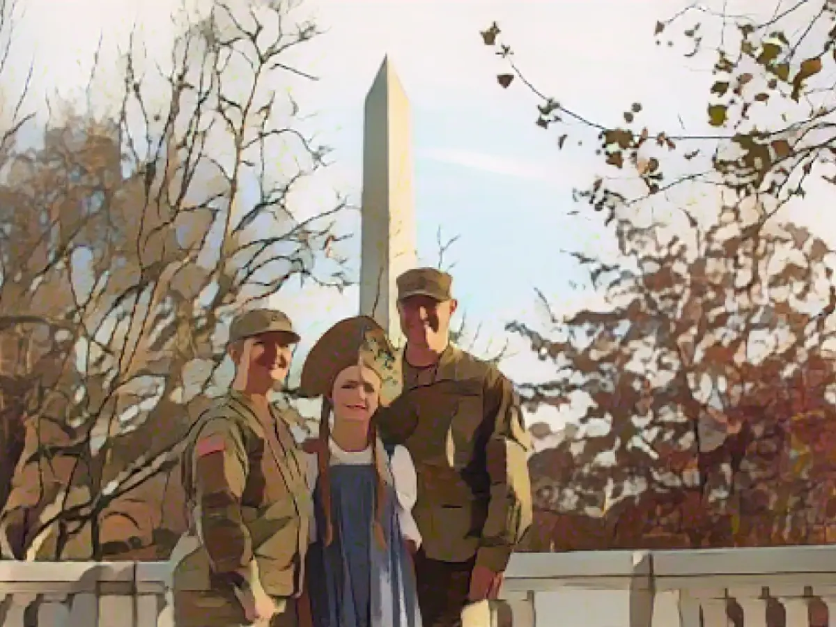 Da sinistra, il sergente dell'esercito di prima classe Christina Wensel, Willa Wensel e il sergente maggiore Benjamin Wensel posano per una foto presso la sede nazionale delle Figlie della Rivoluzione Americana a Washington, DC, il 30 novembre 2023.