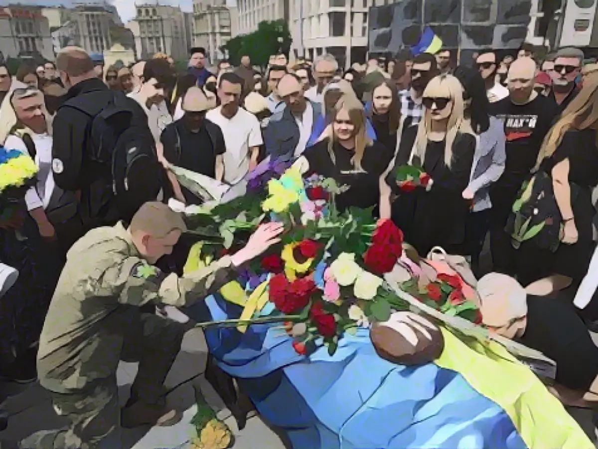 Une foule de personnes en deuil rend hommage à Roman lors d'une cérémonie d'adieu à Kiev, en Ukraine, le 18 juin 2022.