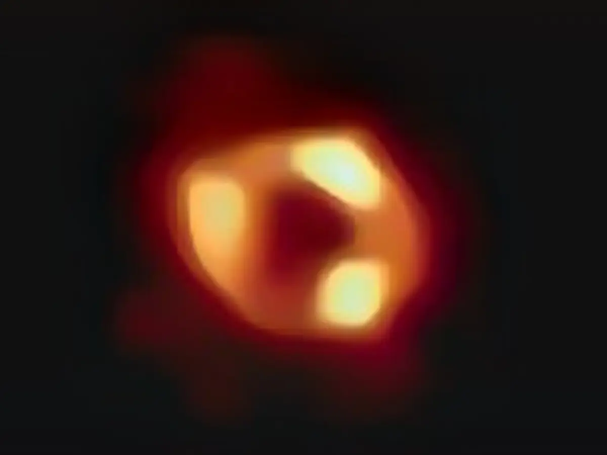 Aceasta este prima imagine a lui Sgr A*, gaura neagră supermasivă din centrul galaxiei noastre, cu un fundal negru adăugat pentru a se potrivi pe ecrane mai largi. Este prima dovadă vizuală directă a prezenței acestei găuri negre. Imaginea a fost captată de Event Horizon Telescope (EHT), o rețea care a unit opt radioobservatoare existente pe planetă pentru a forma un singur telescop virtual 