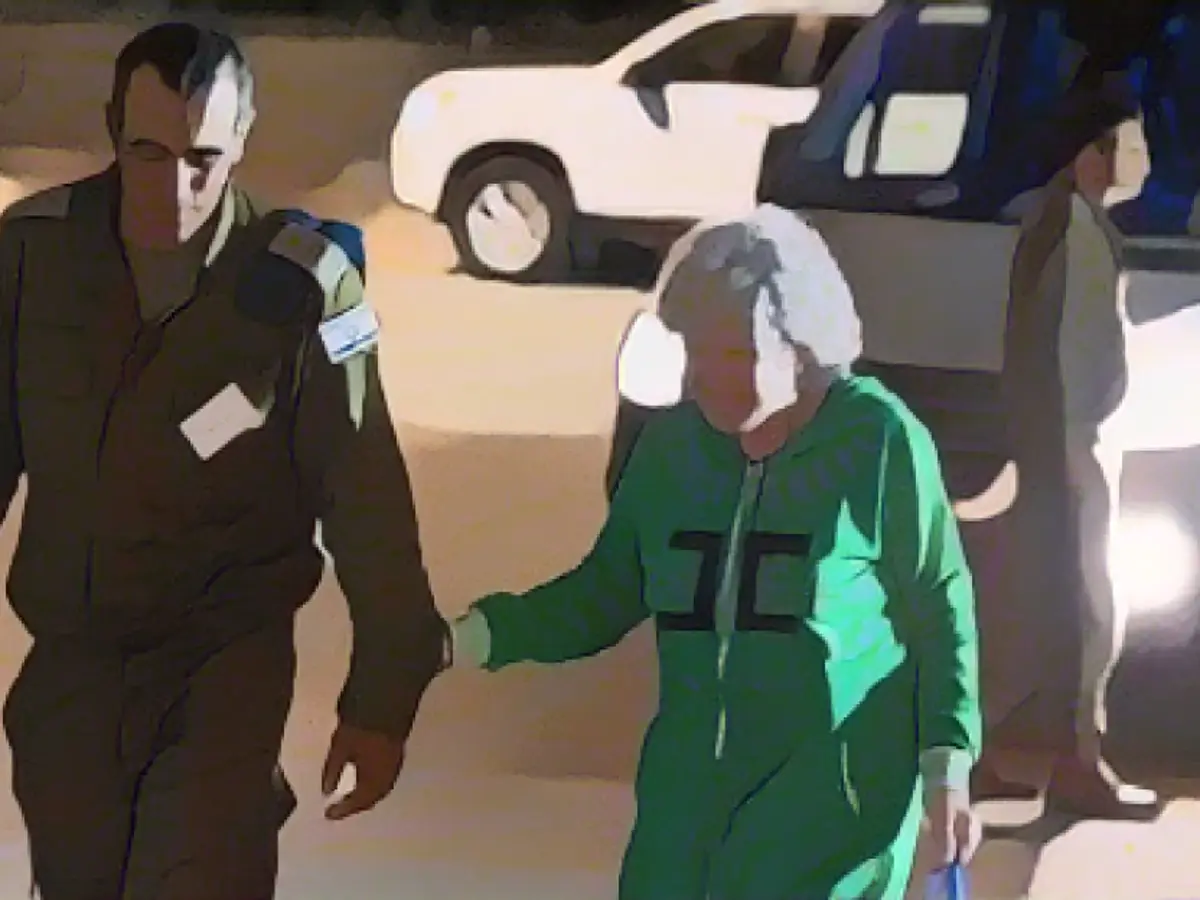 Ruth Munder, a released Israeli hostage, walks with an Israeli soldier shortly after her arrival in Israel on November 24.