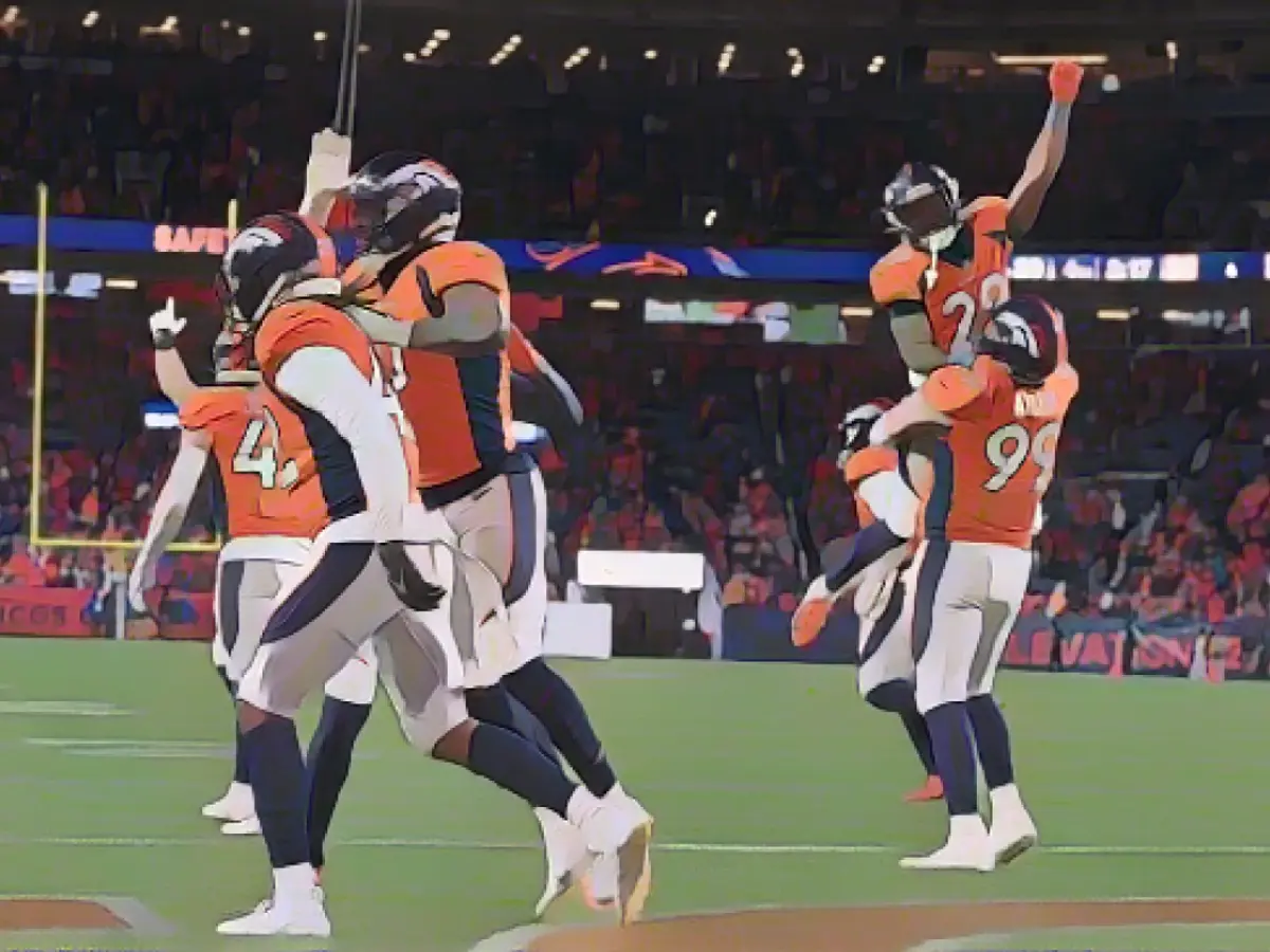 Membri della difesa dei Denver Broncos festeggiano dopo che una safety a fine partita contro i Cleveland Browns ha sancito la vittoria della squadra per 29-12.