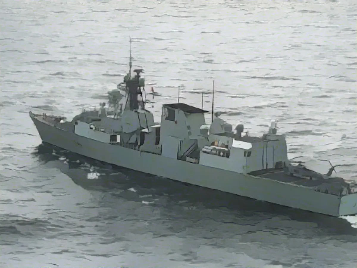 Канадский фрегат HMCS Ottawa виден с вертолета корабля, в то время как вертолет ВМС США стоит на его полетной палубе в Восточно-Китайском море.