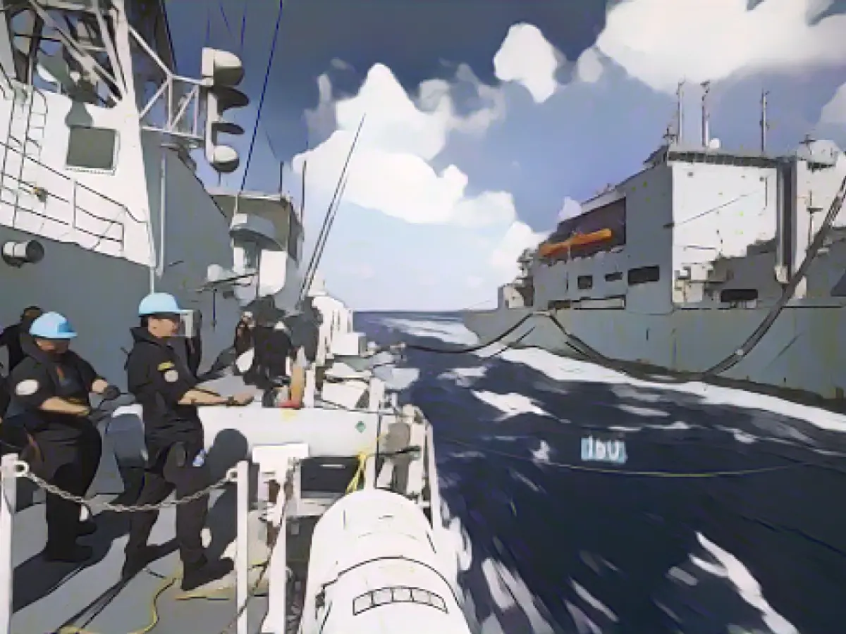 L'équipage à bord du NCSM Ottawa's tient une ligne de distance avec l'USNS Wally Shirra alors que les deux navires effectuent une mission de ravitaillement en mer dans la mer de Chine méridionale, le 30 octobre 2023.