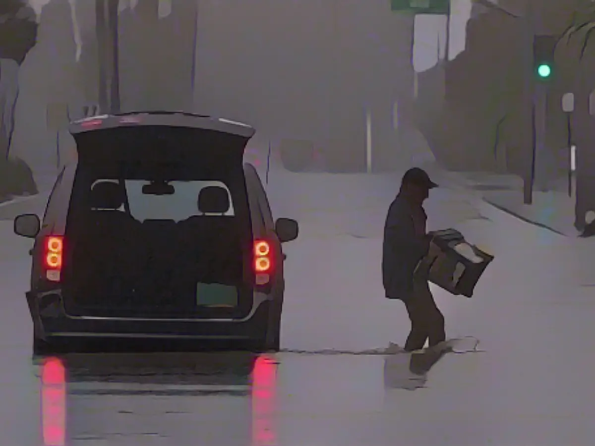 Ein Autofahrer entfernte Habseligkeiten aus seinem Fahrzeug, nachdem er am Sonntag, dem 20. August, in Palm Desert, Kalifornien, auf einer überfluteten Straße gestrandet war.