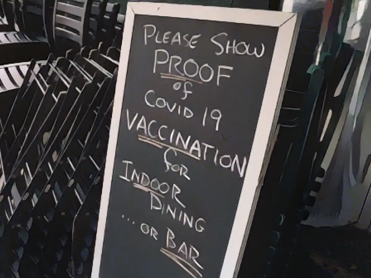 Auf einem Schild in einem New Yorker Restaurant steht: „Zum Essen im Innenbereich … oder in einer Bar, bitte zeigen Sie einen Nachweis der Covid-19-Impfung.“