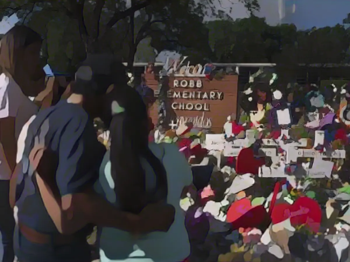 Menschen besuchen am Donnerstag, den 2. Juni 2022, eine Gedenkstätte an der DeRob Elementary School in Uvalde, Texas, um den Opfern ihren Respekt zu erweisen, die bei der Schießerei in der Schule letzte Woche ihr Leben verloren haben.