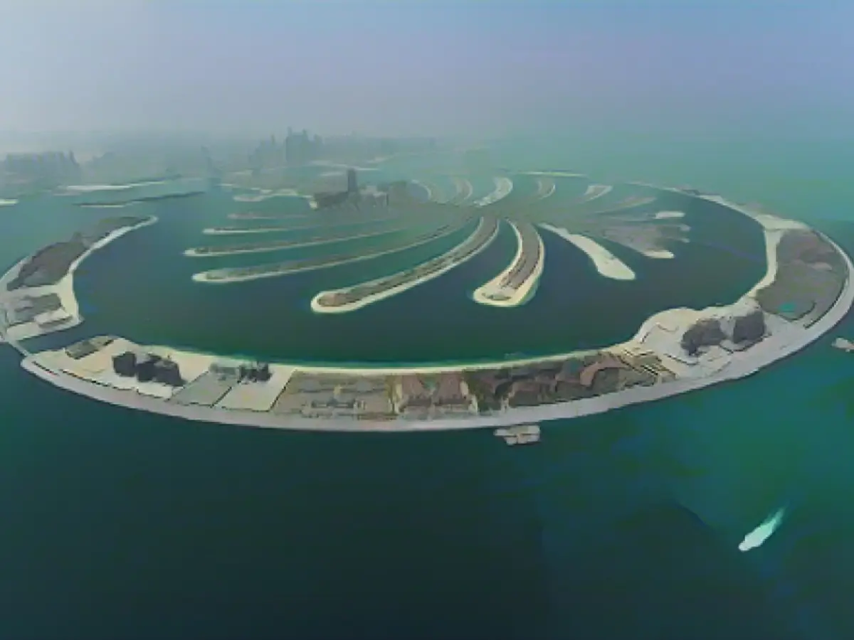 La Palmera Jumeirah es un conjunto artificial de islas frente a la costa continental de Dubai. Esta vista aérea desde un hidroavión muestra la forma de palmera, rodeada por un rompeolas semilunar que protege las islas de vientos y olas fuertes.