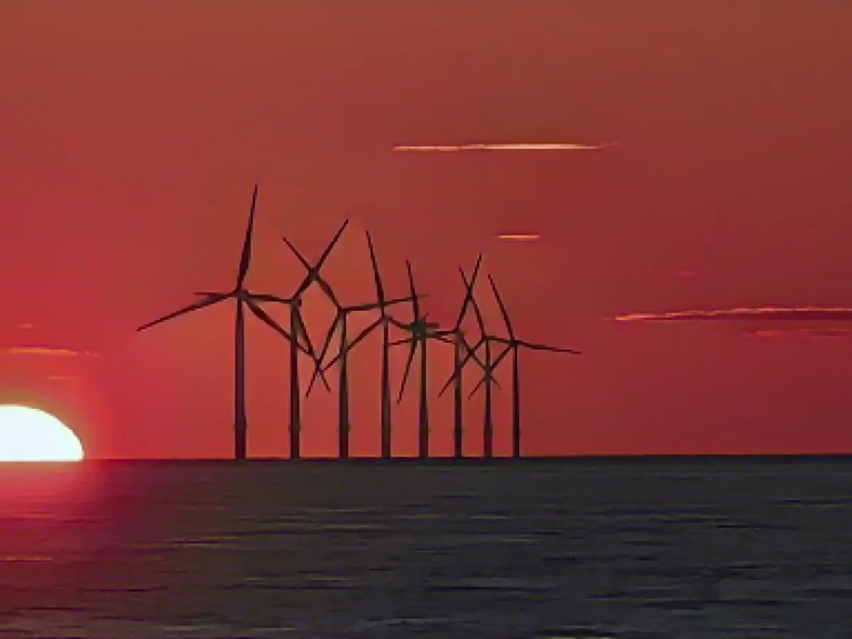 Die Sonne geht im Mai 2021 hinter dem Offshore-Windpark Burbo Bank in der Liverpool Bay im Nordwesten Englands unter.