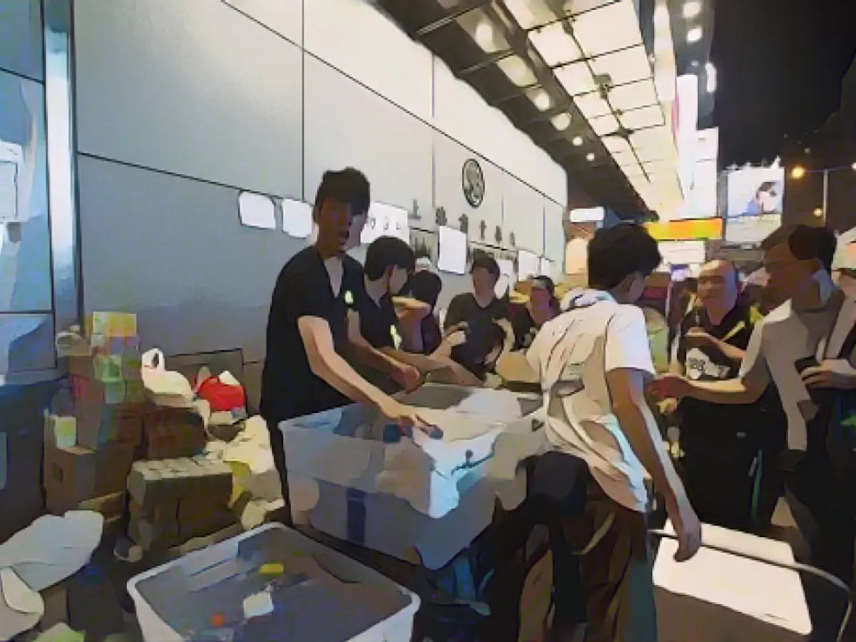 Pro-democracy protesters collect and distribute supplies in Mong Kok Pro-democracy protesters work together to collect and distribute supplies in Mong Kok.