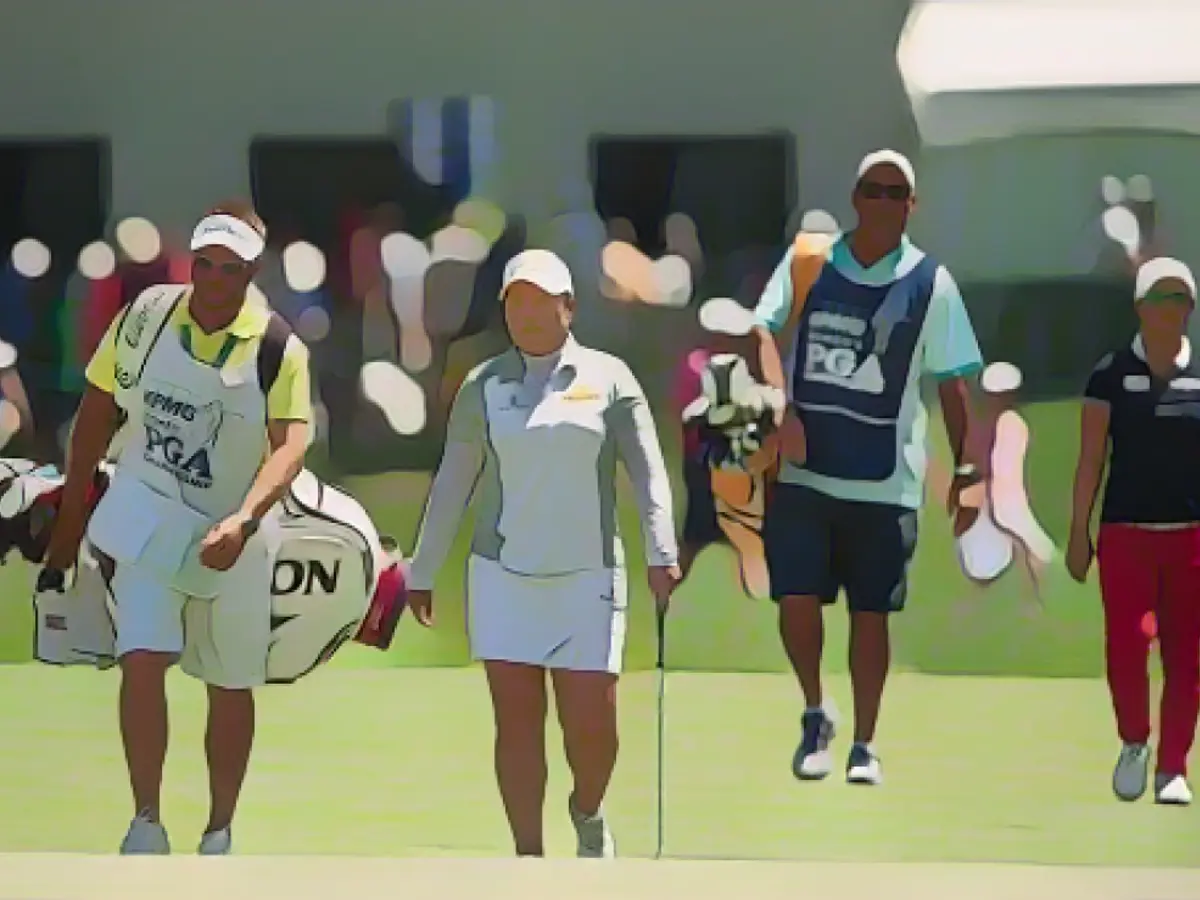 Inbee Park (Zweite von links) und ihr Caddie laufen mit Kim (rechts) und ihrem Caddie während der Endrunde der Women's PGA Championship 2015 über das Fairway.