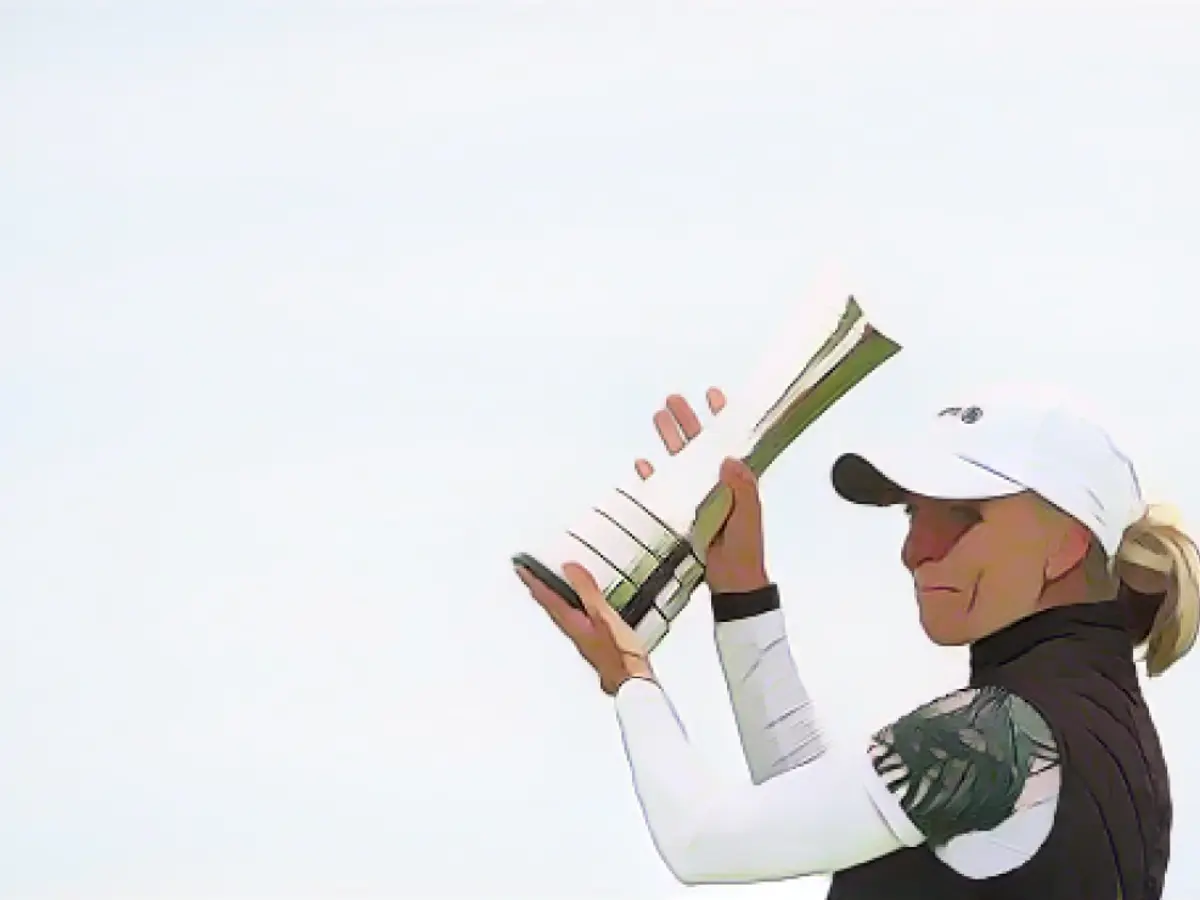 Popov holt die Trophäe nach dem Sieg bei den Women's British Open in die Höhe.