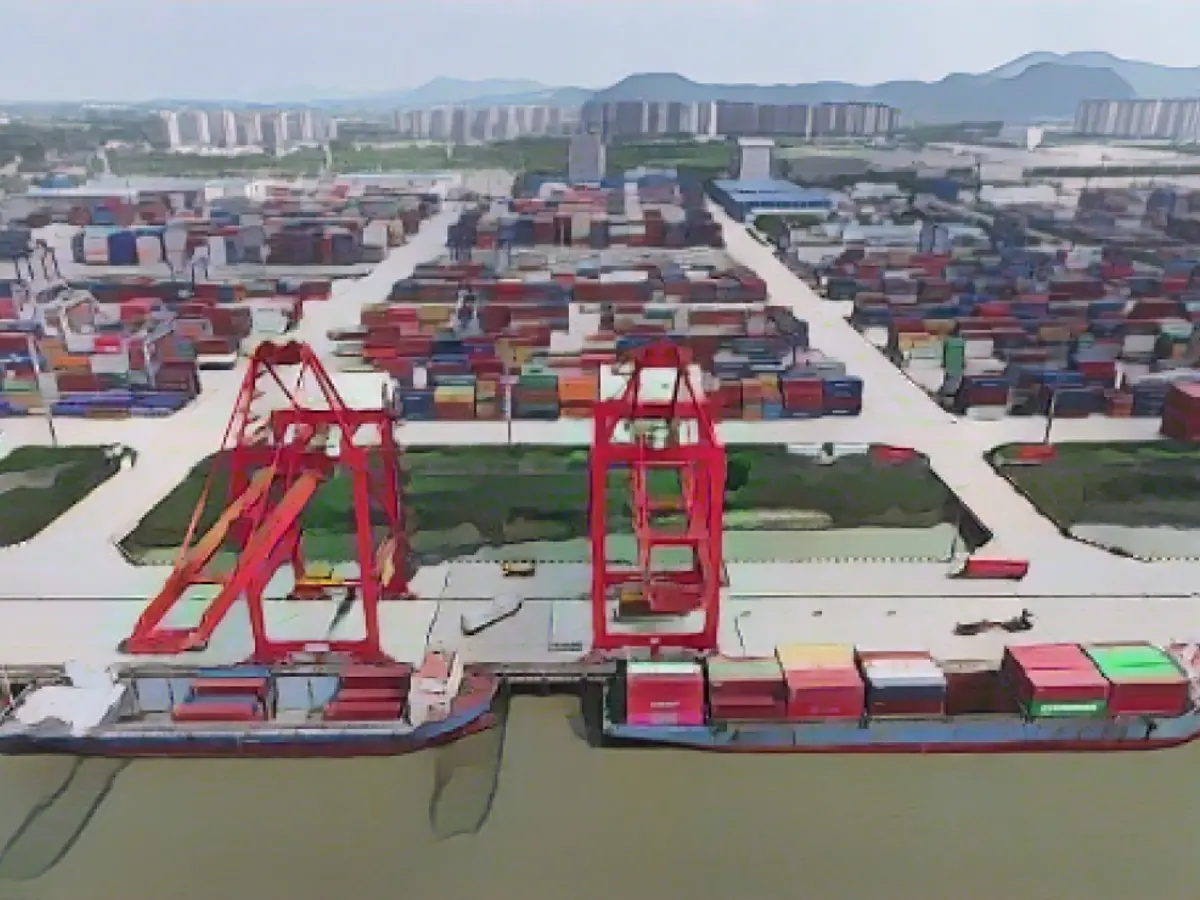 Ein Lkw fährt im August im Hafen von Nanjing, Provinz Jiangsu, zwischen Containern hindurch.