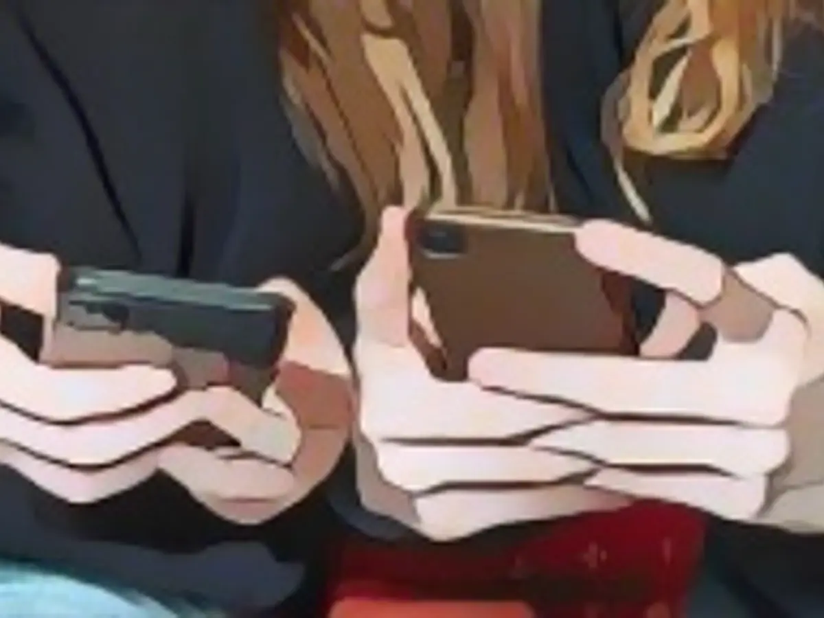 Подростки пользуются мобильными телефонами