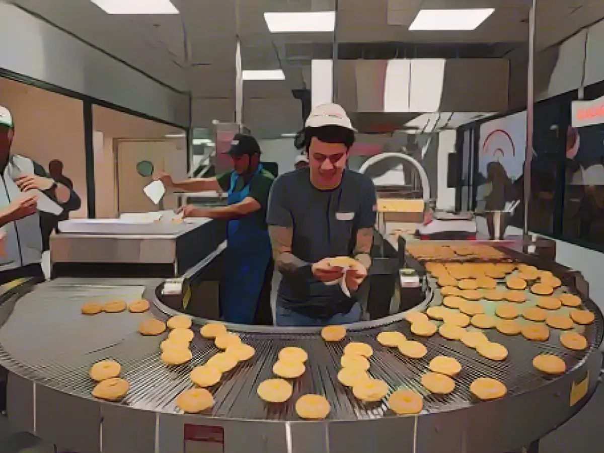 I lavoratori di Krispy Kreme preparano le ciambelle nel primo negozio dell'azienda in Francia il 4 dicembre.