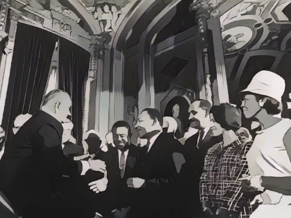 Президент США Линдон Б. Джонсон приветствует лидеров движения за гражданские права Мартина Лютера Кинга-младшего, Ральфа Абернати и Кларенса Митчелла после подписания закона о праве голоса в 1965 году.