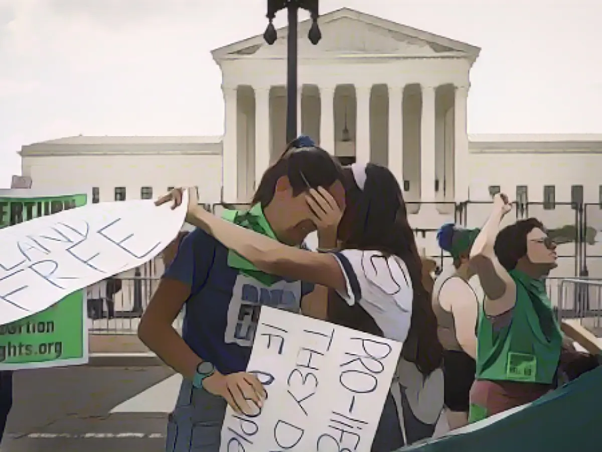 Активистки движения за права абортариев Кэрри Макдональд (слева) и Сорайя Бата реагируют на решение, отменившее эпохальное решение по абортам Роу против Уэйда, у здания Верховного суда США 24 июня 2022 года в Вашингтоне.