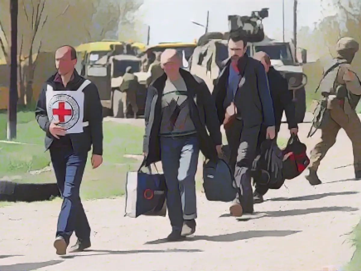 Гражданские лица в сопровождении членов Красного Креста направляются в село Безыменное Донецкой области, Украина.