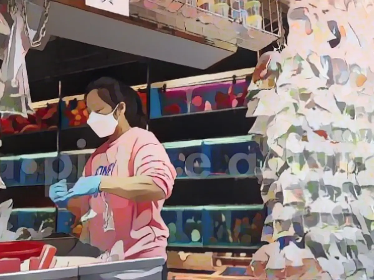 Декоративные рыбки висят в пластиковых пакетах для продажи в зоомагазине в Гонконге.