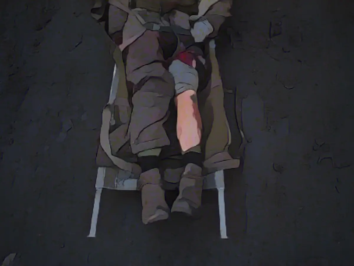 Раненый на войне солдат лежит на носилках в ожидании медицинской помощи