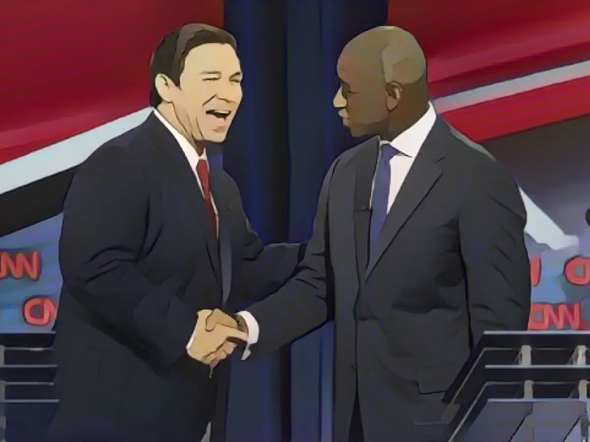ДеСантис пожимает руку кандидату в губернаторы от Демократической партии Эндрю Гиллуму после дебатов на CNN в октябре 2018 года.
