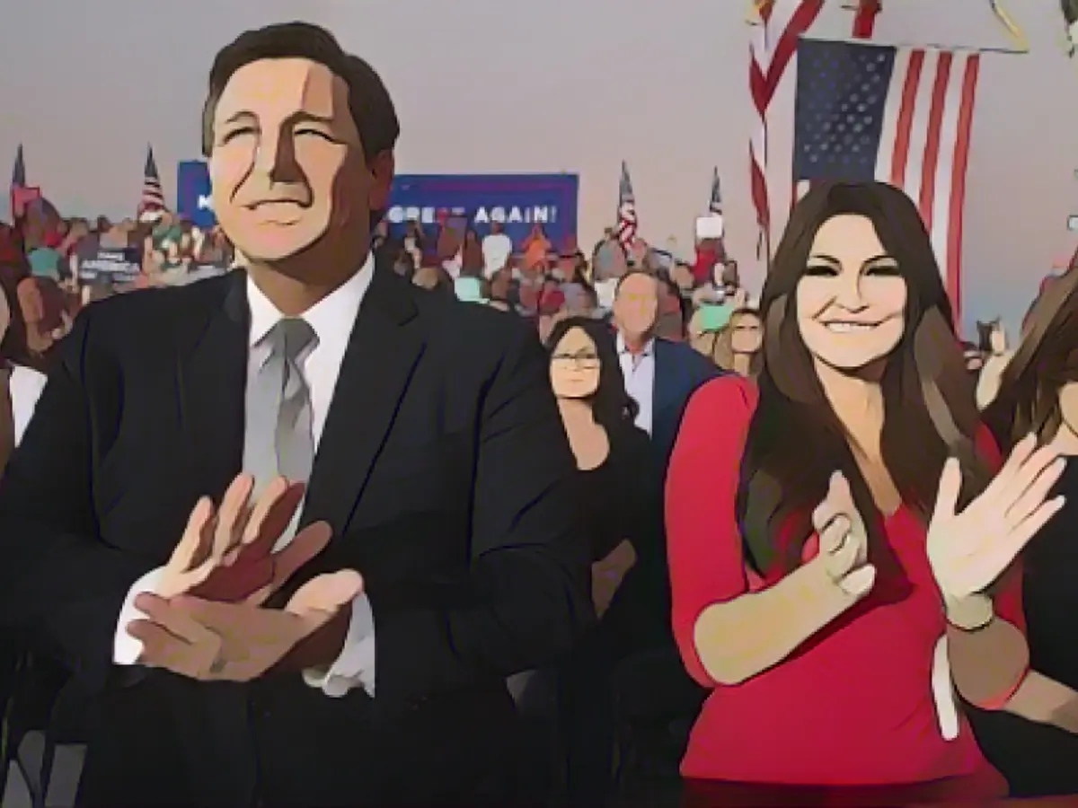 ДеСантис и Кимберли Гилфойл, финансовый председатель кампании Трампа, аплодируют во время митинга Трампа в Сэнфорде, Флорида, в октябре 2020 года.