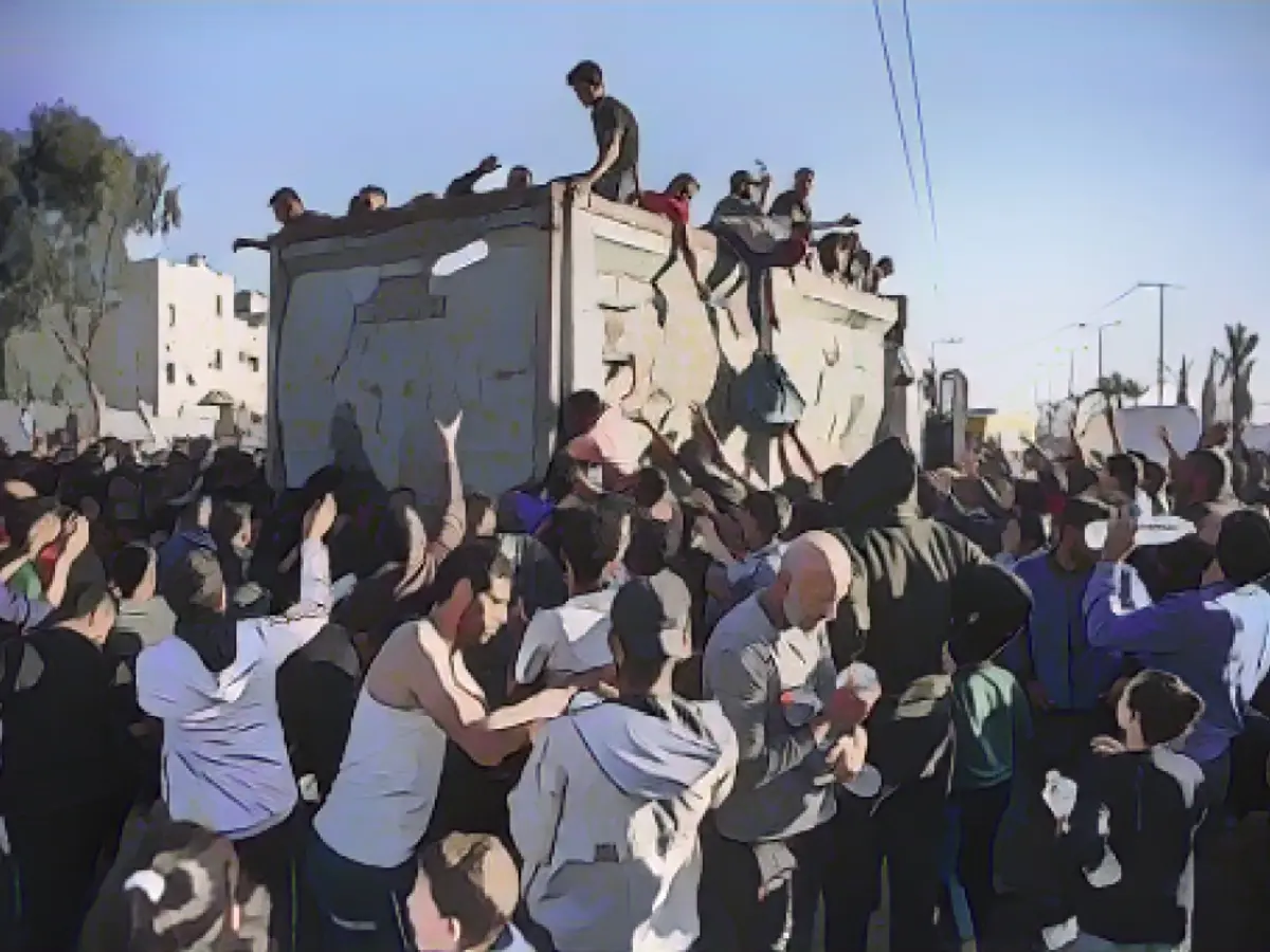 Палестинцы стекаются к грузовику с питьевой водой на фоне растущего голода и жажды в Рафахе, южная часть сектора Газа, 11 декабря.