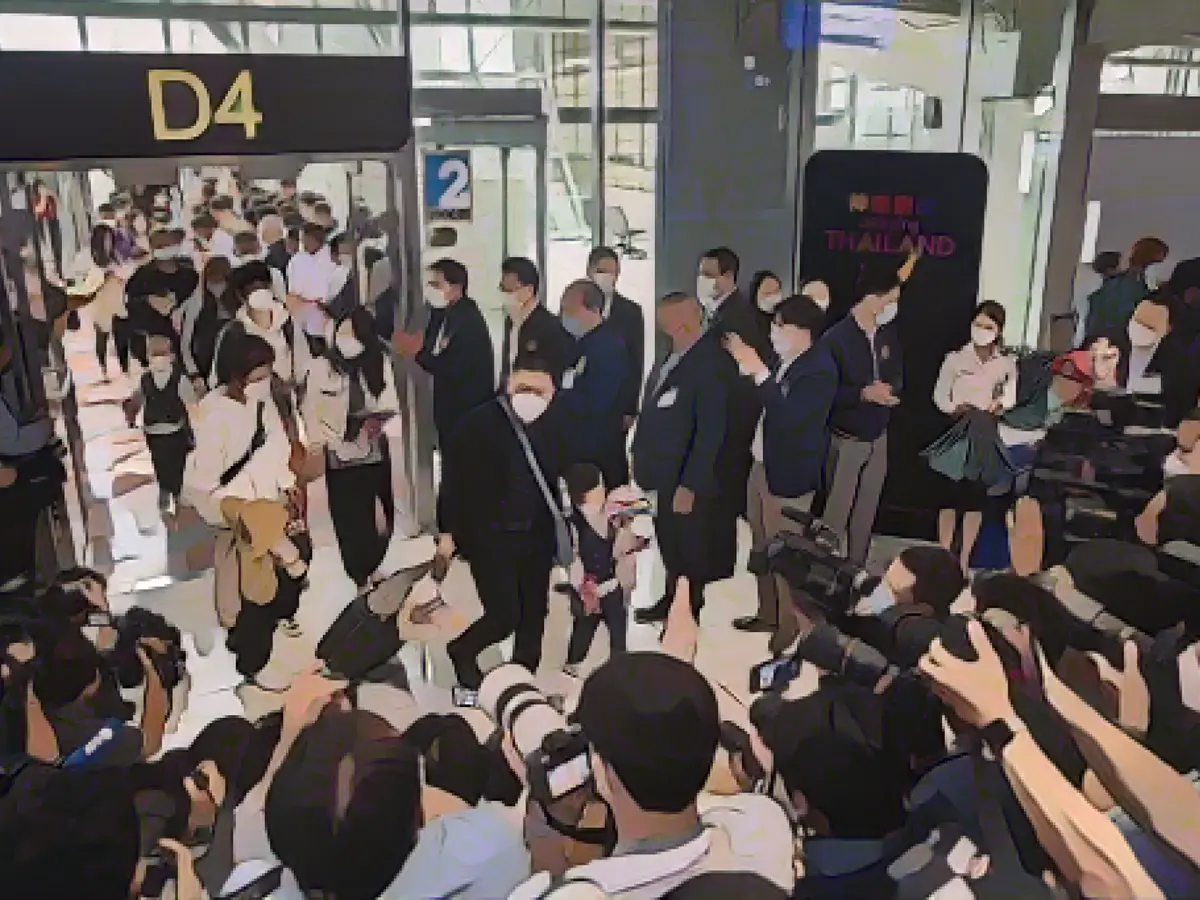 Китайских путешественников встречают представители тайских СМИ по прибытии в аэропорт Суварнабхуми в Бангкоке.