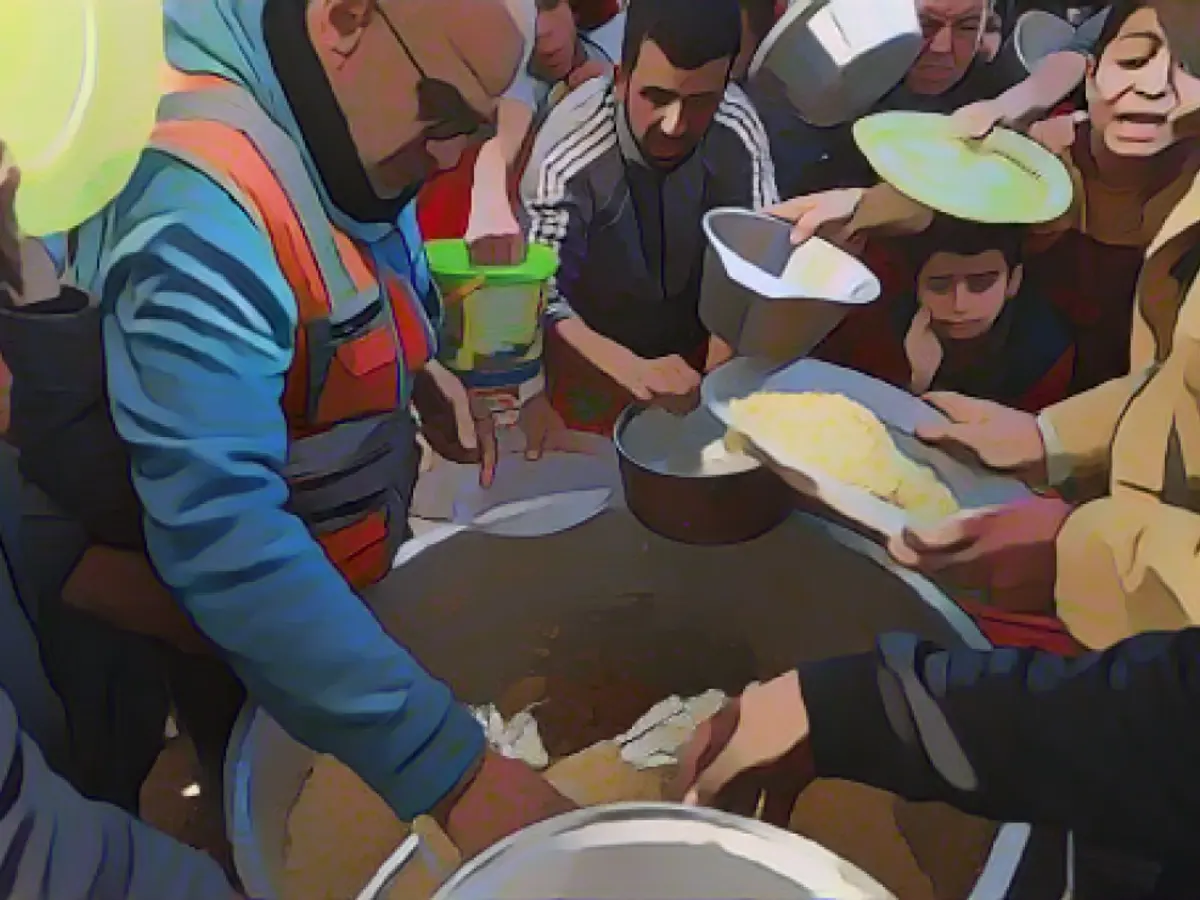 Vertriebene Palästinenser warten am 30. November in Rafah im Süden des Gazastreifens in der Schlange auf Lebensmittelspenden. Der gravierende Mangel an Nahrungsmitteln, Treibstoff und Wasser hat zu steigenden Preisen geführt.