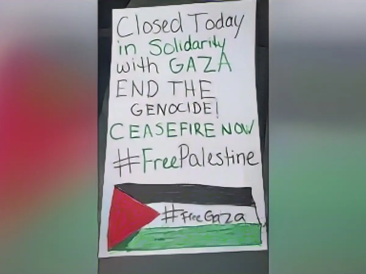 Um estabelecimento comercial exibe um cartaz informando os clientes que está fechado em solidariedade com os palestinianos em Gaza e apelando a um cessar-fogo.