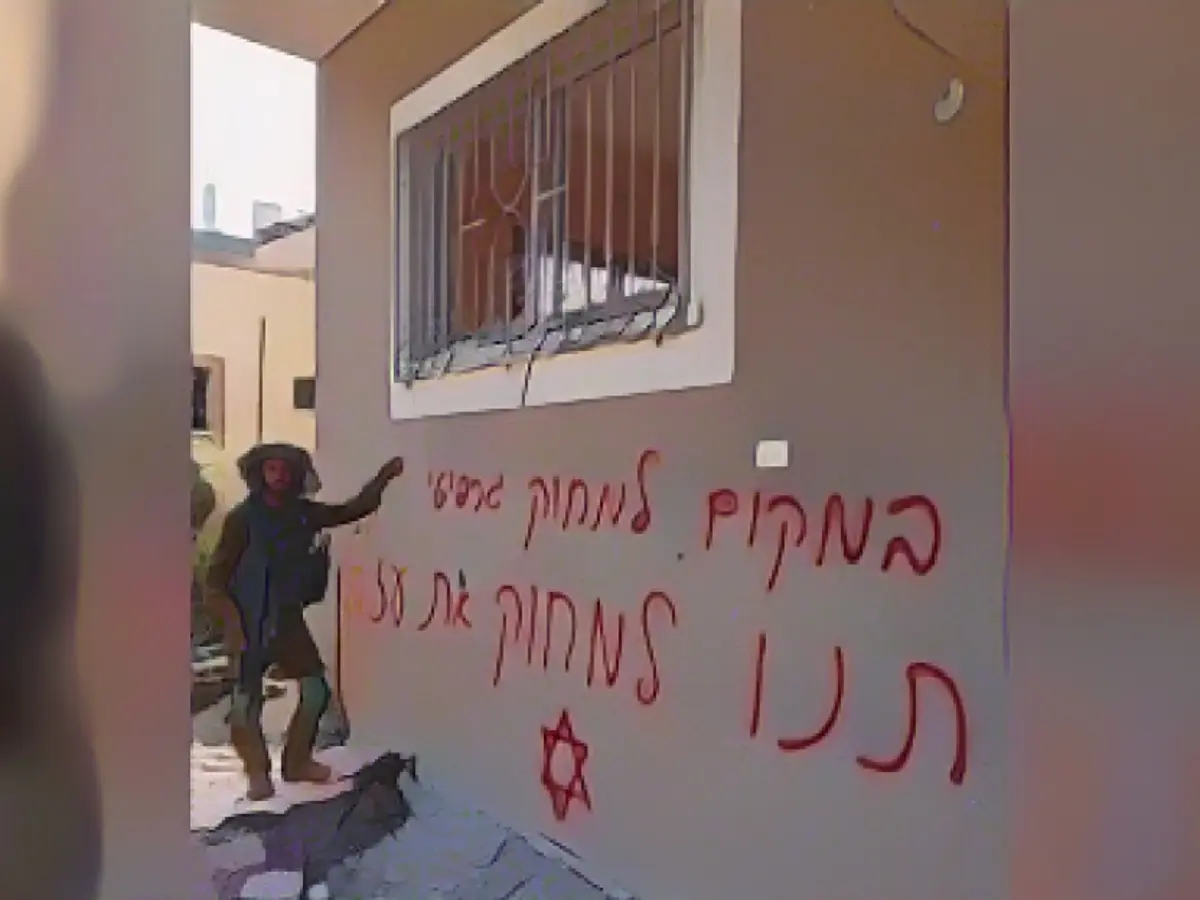 На снимке, опубликованном в Интернете, изображен израильский солдат рядом с надписью 