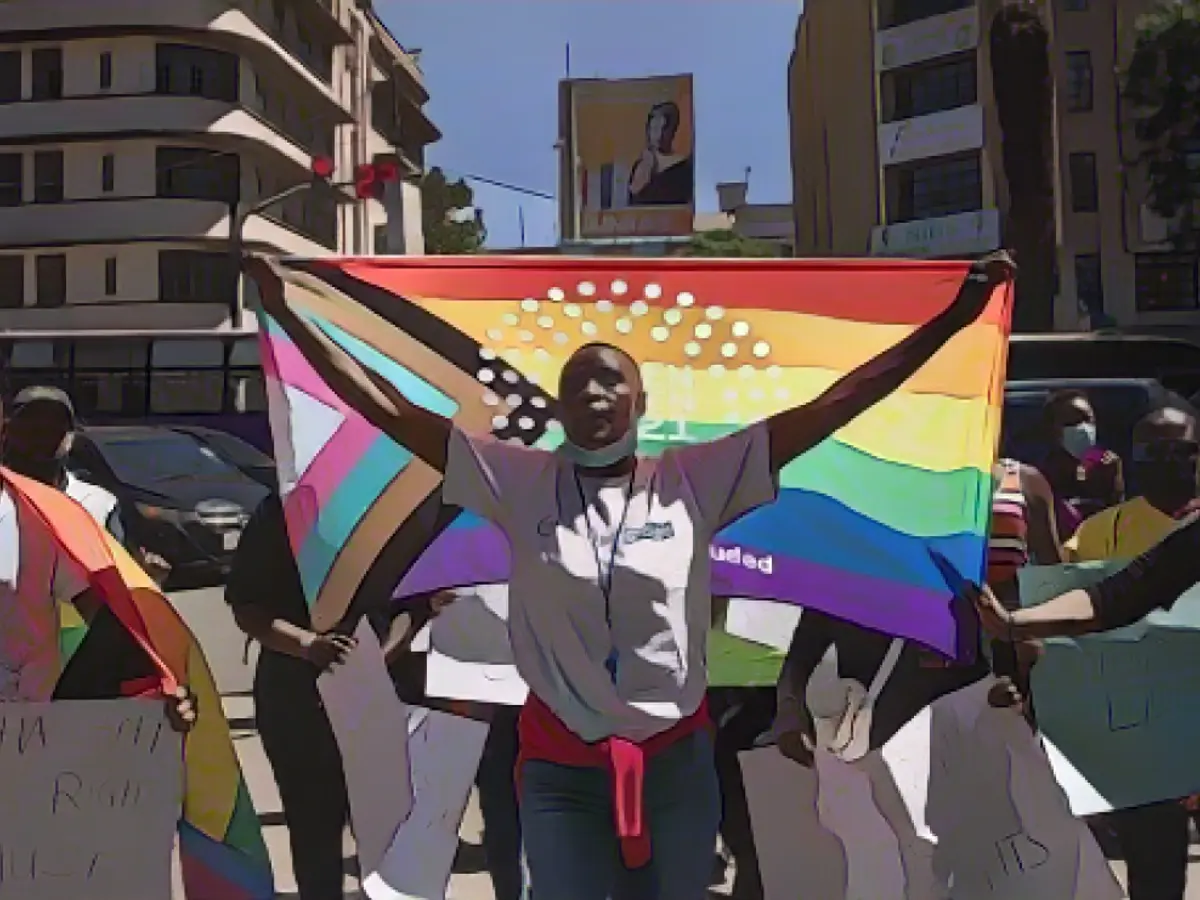 Una donna tiene in mano una bandiera dell'orgoglio durante una protesta organizzata da The Queer Republic a Nairobi nel gennaio 2022.