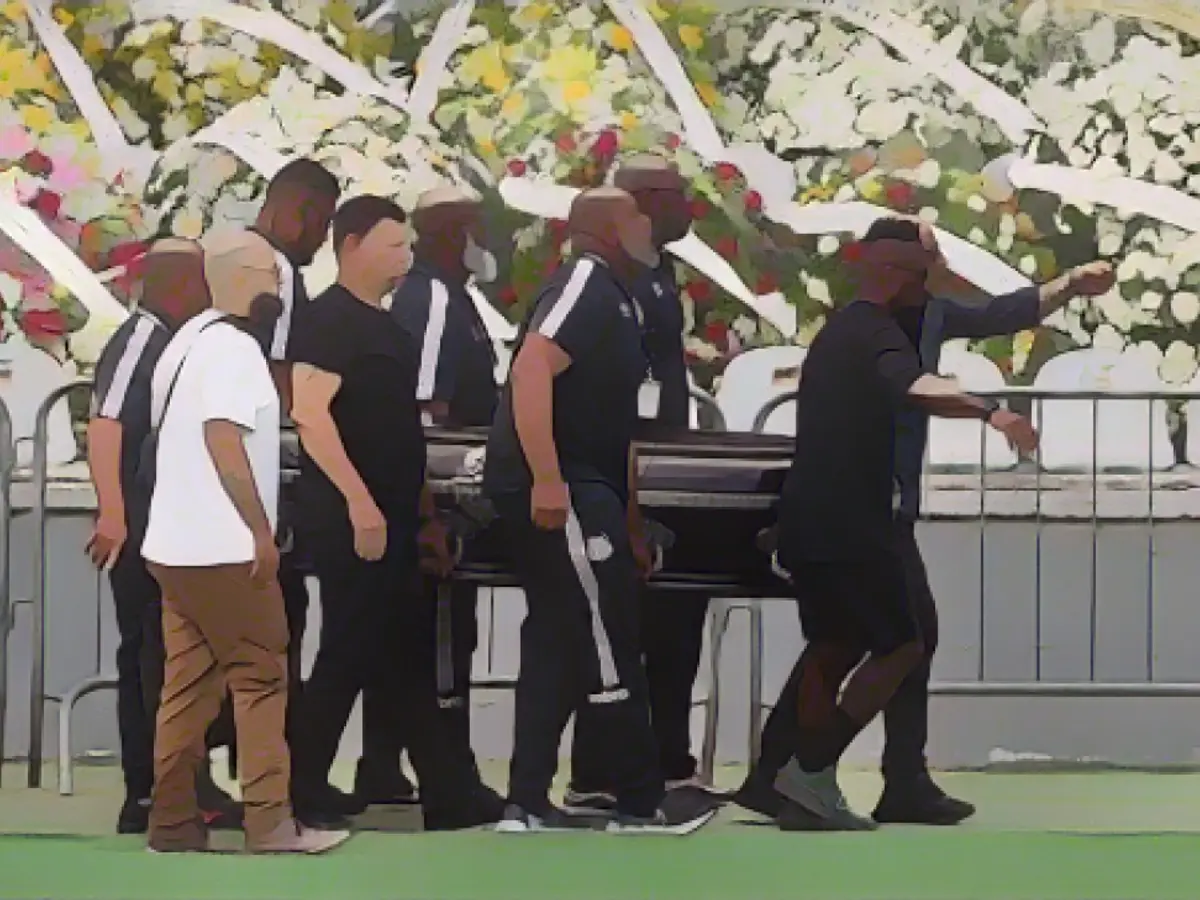 Жрецы несут гроб легенды бразильского футбола Пеле к центральному кругу стадиона 