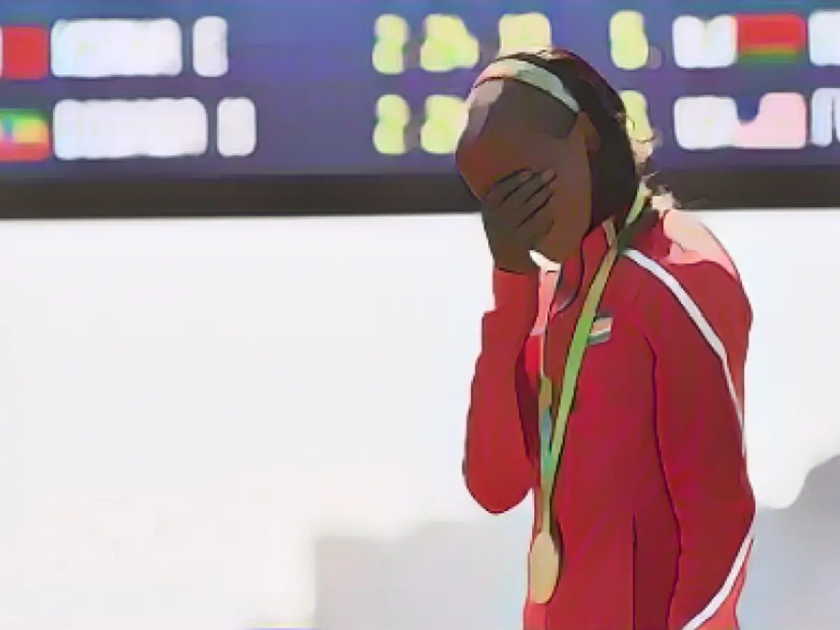 Кенийская спортсменка Джемима Сумгонг переживает во время церемонии награждения на подиуме в женском марафоне в воскресенье, 14 августа. Сумгонг - первая женщина, завоевавшая золотую медаль в олимпийском марафонском беге для Кении.