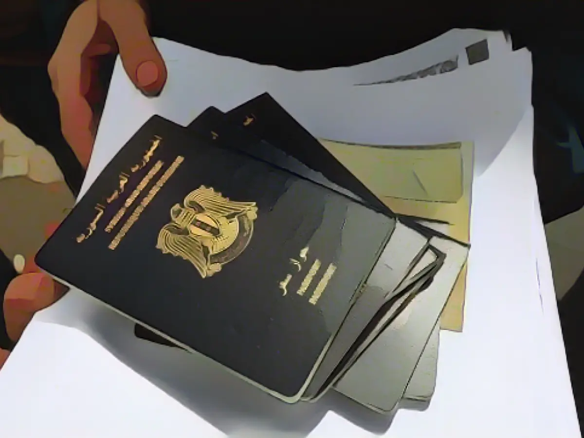 Беженка держит в руках сирийский паспорт, стоя в очереди на иммиграцию у посольства Германии в Бейруте в 2015 году.
