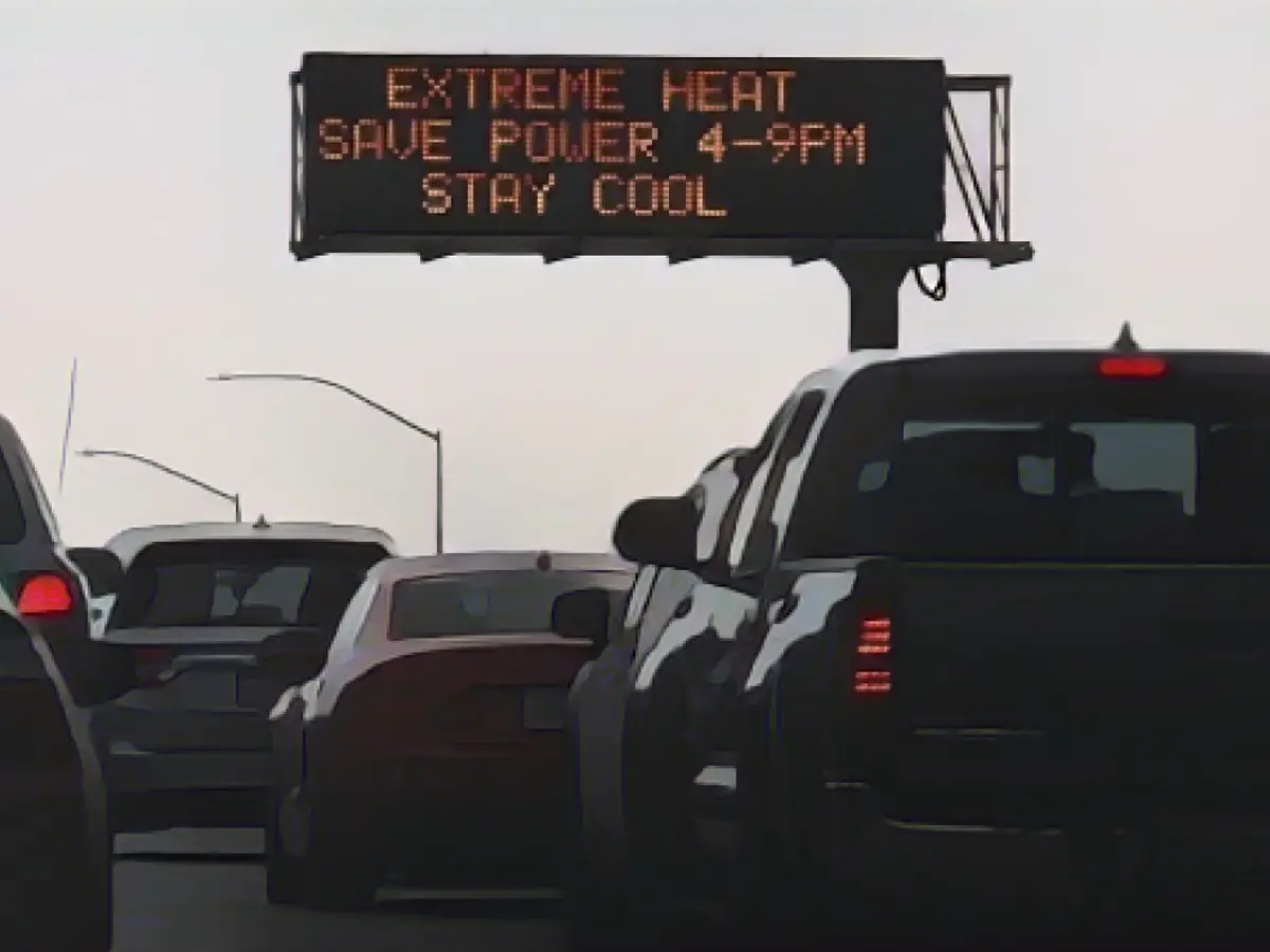 Автомобили проезжают мимо знака на 110-й автостраде, предупреждающего о сильной жаре и призывающего экономить электроэнергию во время аномальной жары в центре Лос-Анджелеса, Калифорния, в пятницу.