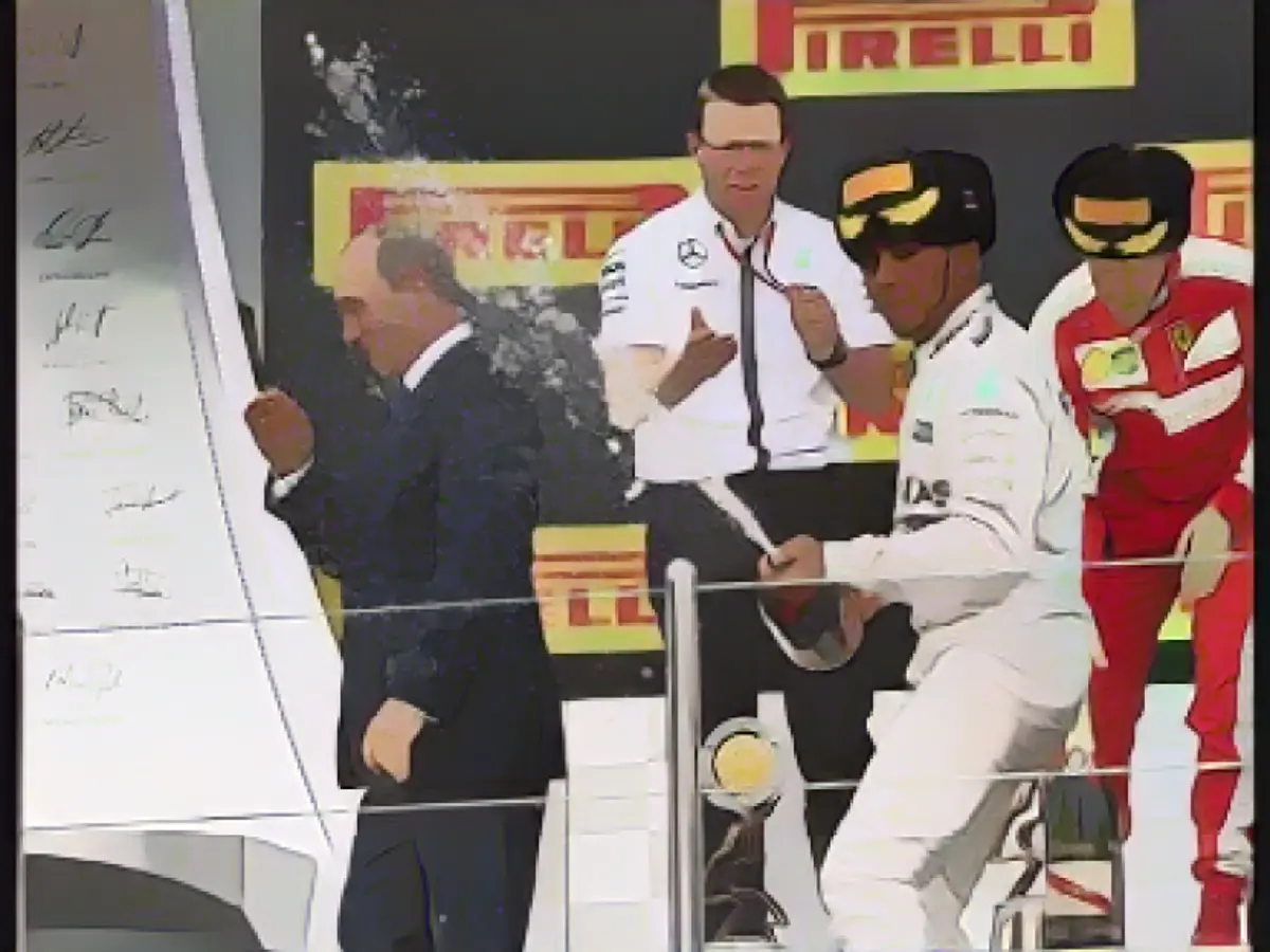 Lewis Hamilton innaffia di champagne Vladimir Putin mentre festeggia la vittoria al GP di Russia 2015