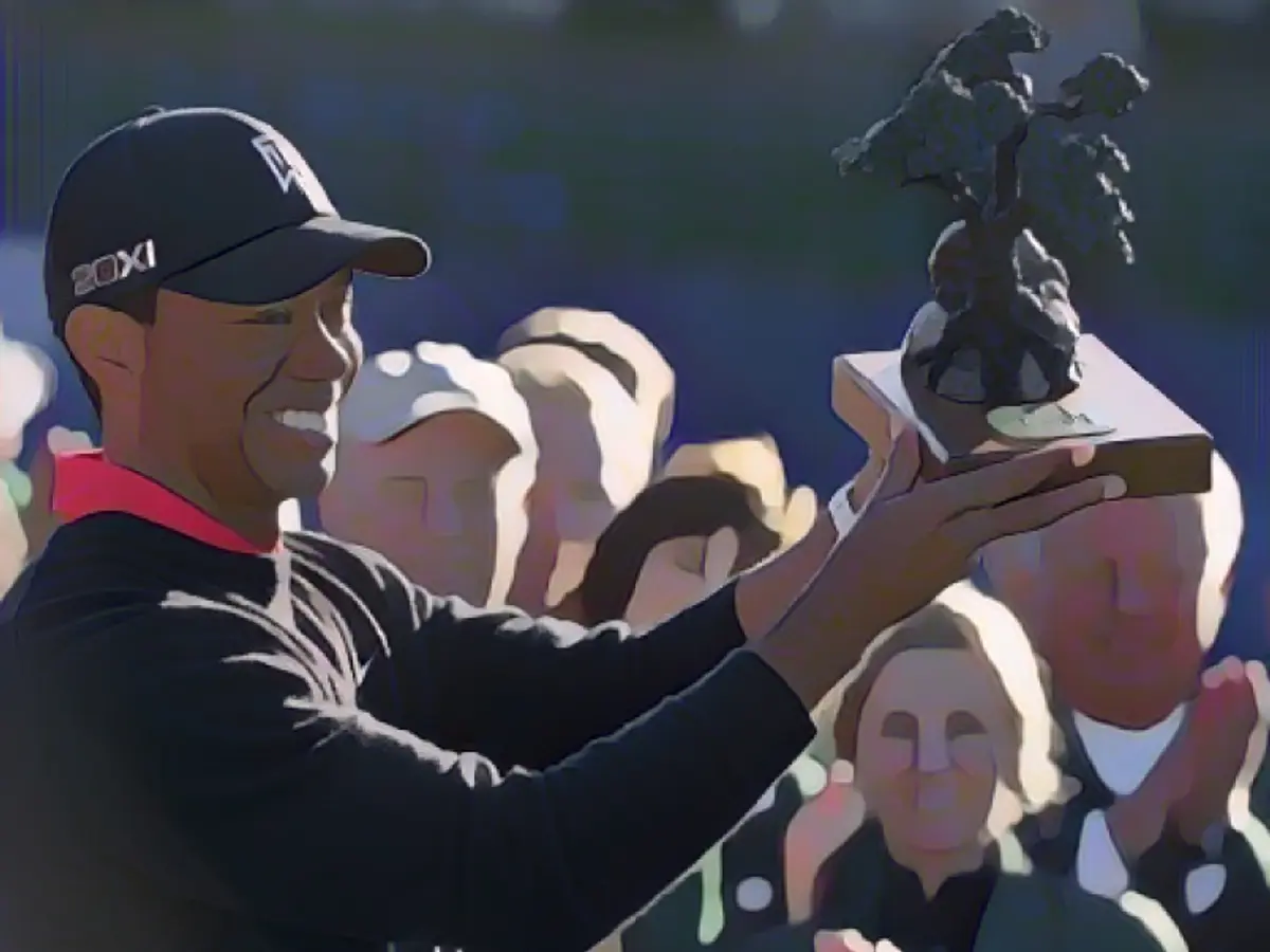 Вудс держит в руках трофей с турнира Farmers Insurance Open в Торри Пайнс в январе 2013 года, где он завоевал свой 75-й титул чемпиона PGA Tour.