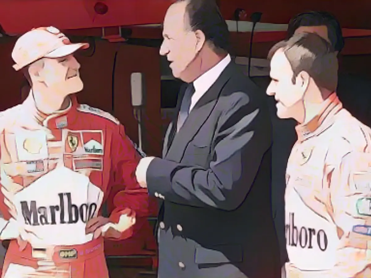 Король Испании Хуан Карлос поздравляет Шумахера после победы на Гран-при Испании Формулы-1 в 2001 году.