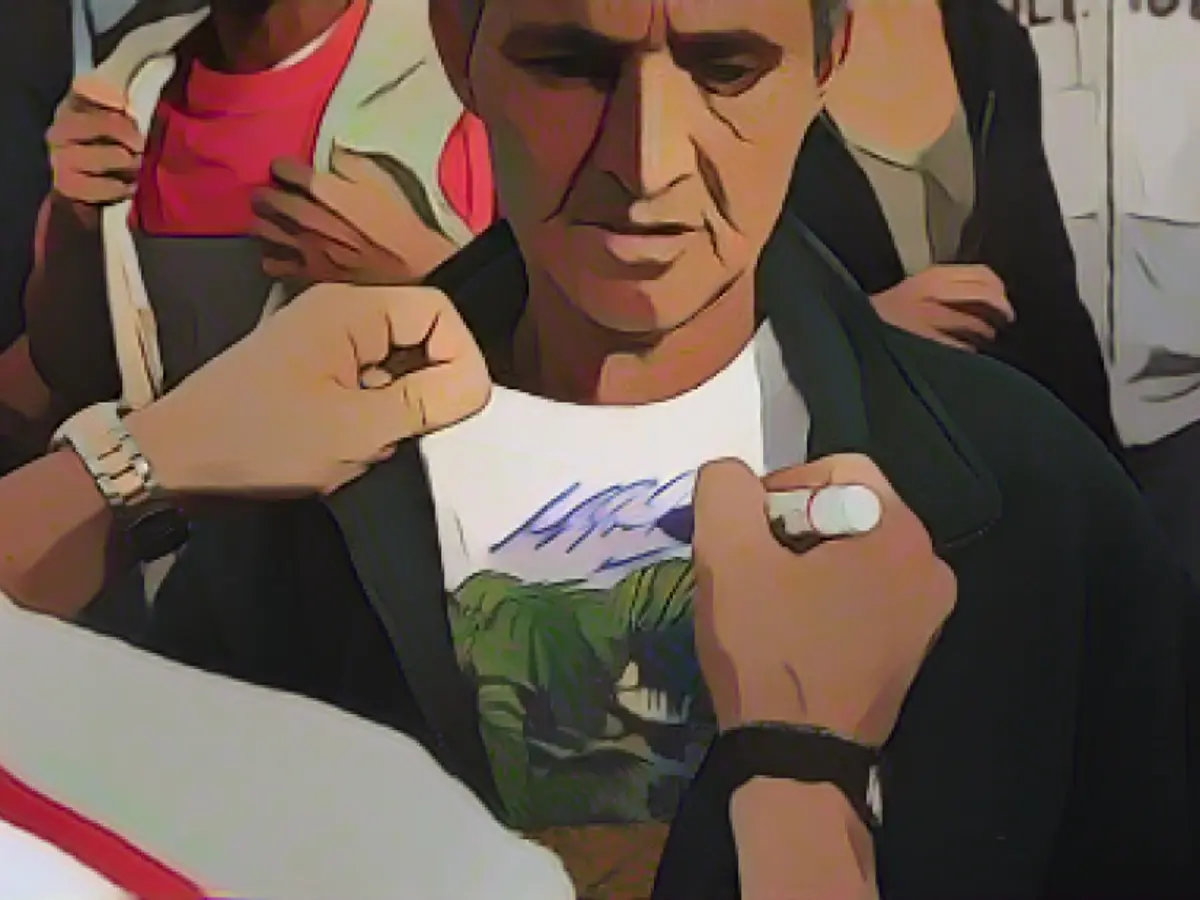 Шумахер дает автограф на футболке жертвы землетрясения в Коста-Рике в 2009 году.