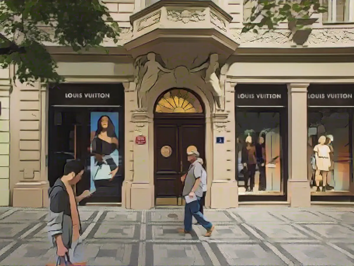 Прохожие проходят мимо бутика Louis Vuitton на улице Парижска в Праге, Чешская Республика.