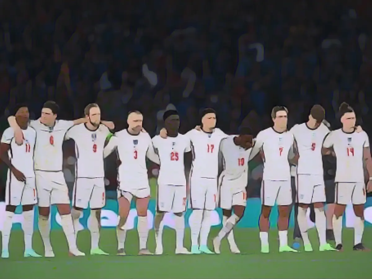 Игроки сборной Англии наблюдают за серией пенальти во время финального матча чемпионата УЕФА Евро-2020 между сборными командами Италии и Англии на стадионе 