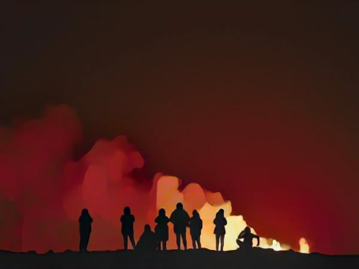 Des personnes observent le volcan sur la péninsule de Reykjanes, dans le sud-ouest de l'Islande.