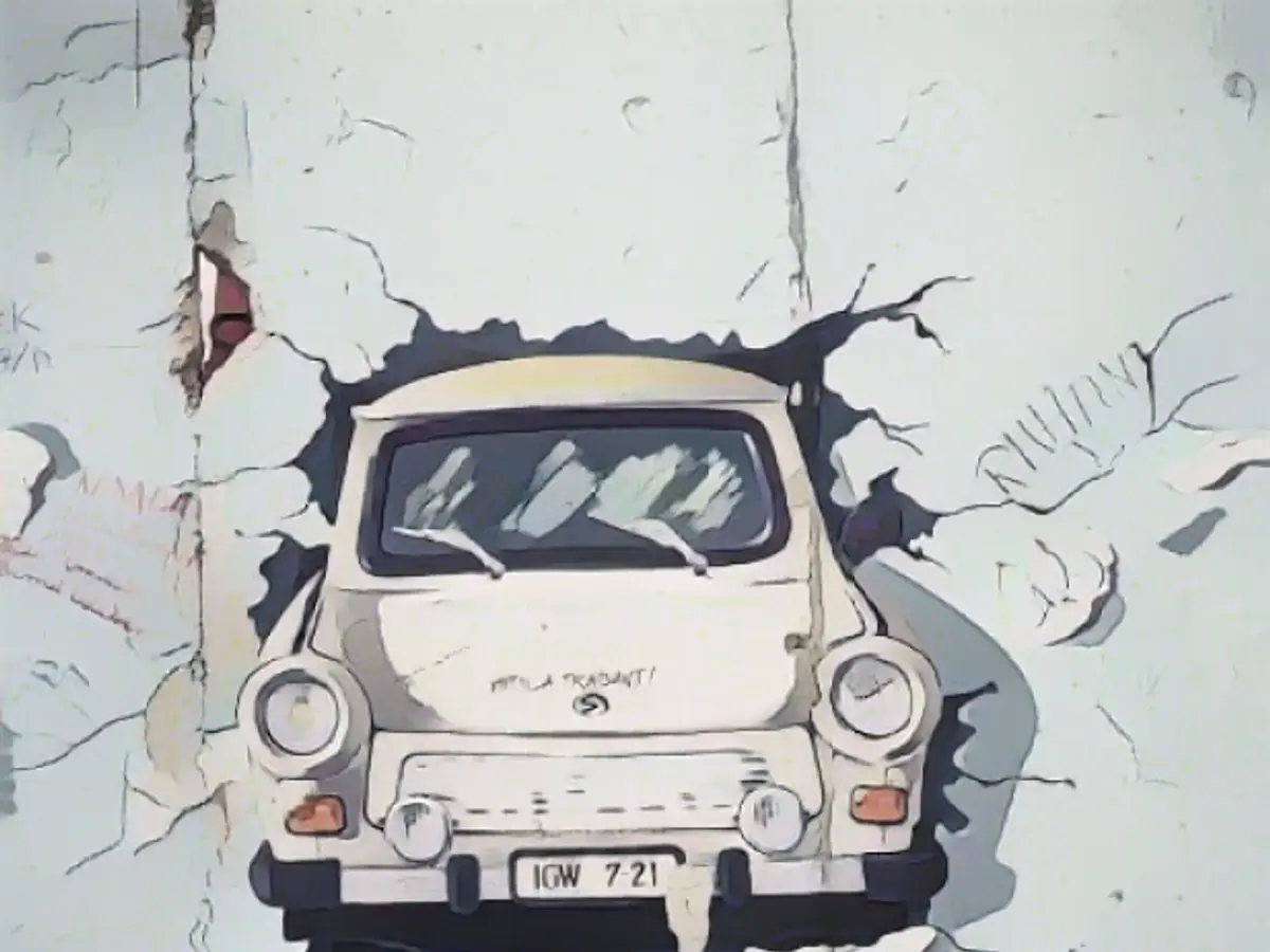 Картина с изображением автомобиля Trabant, пробивающего стену в Берлине после объединения, август 1993 года. Формула Е надеется, что субботняя гонка станет еще одним прорывом для электромобилей.