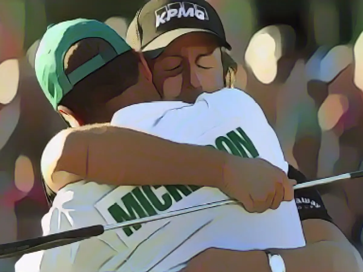 Mickelson umarmte seinen Caddie, Jim „Bones“ McKay, nachdem er am 18. Loch den Putt gemacht hatte, um das Masters 2010 zu gewinnen.