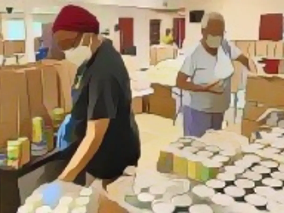 Волонтеры организуют коробки с едой в организации Beyond the Sanctuary в Рочестере, Нью-Йорк, в июне 2021 года.