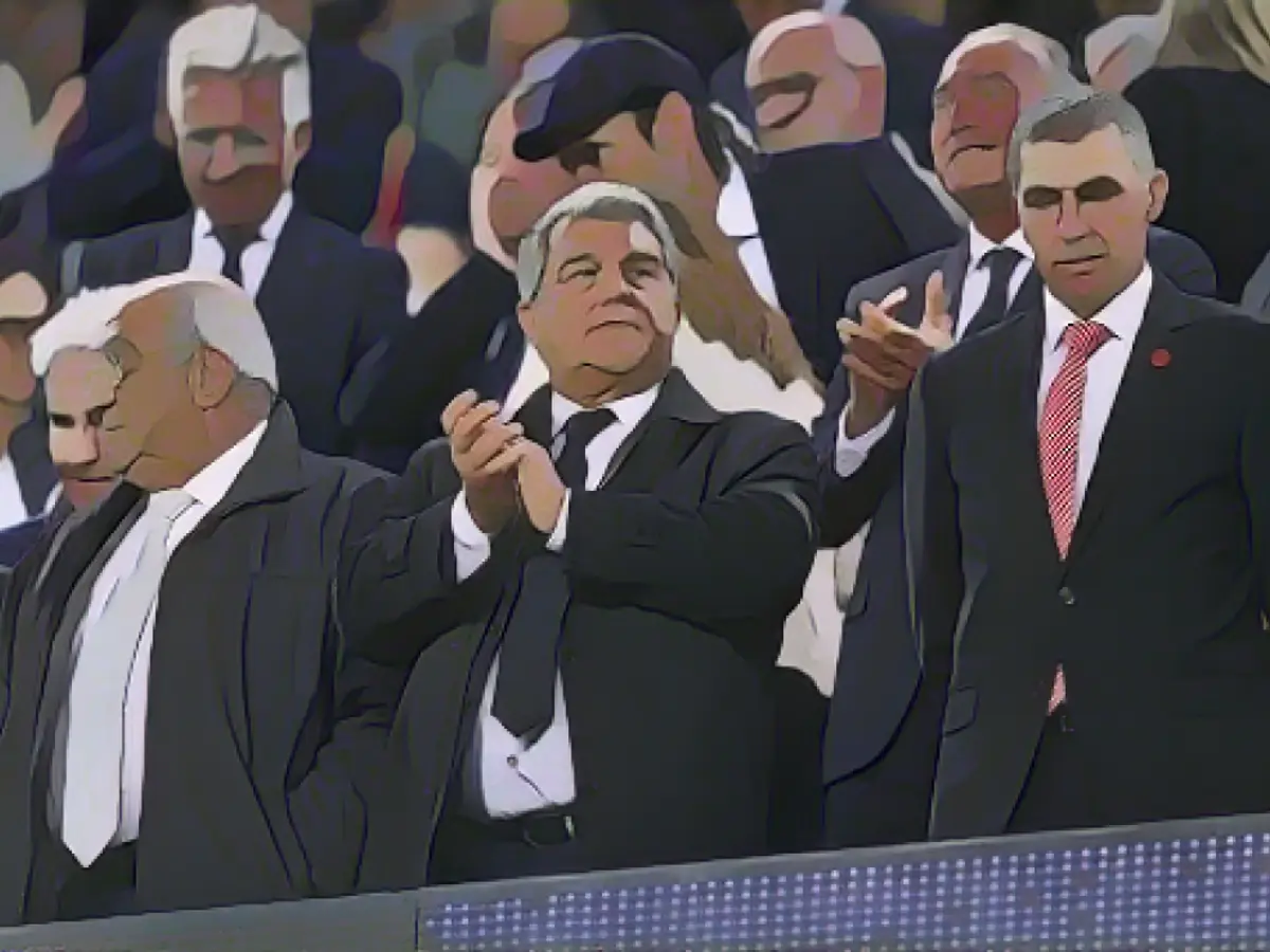 O presidente do FC Barcelona, Joan Laporta (C), e o presidente do Girona, Delfi Geli (R), antes do jogo da LaLiga entre os dois clubes no Camp Nou, a 10 de abril.